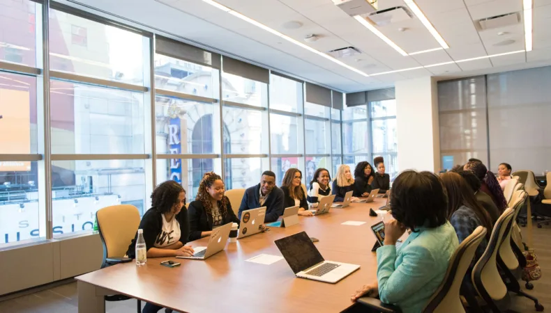 Board room with women from diverse backgrounds.